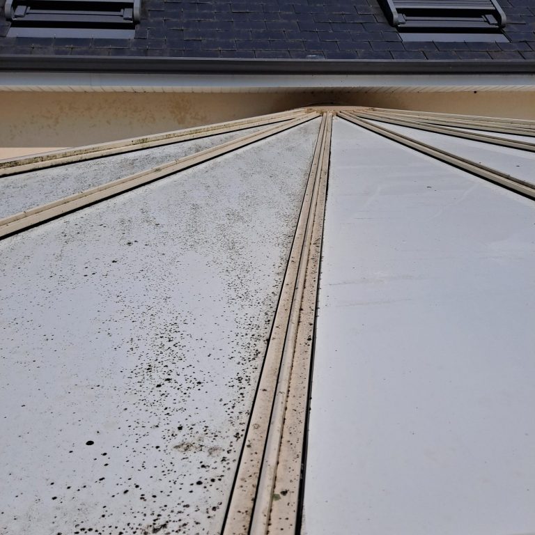 Toit d'un bâtiment avec des lignes de fuite, présentant de la saleté et des marques.